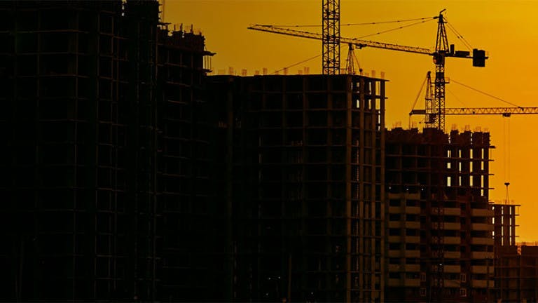 City skyline with construction cranes